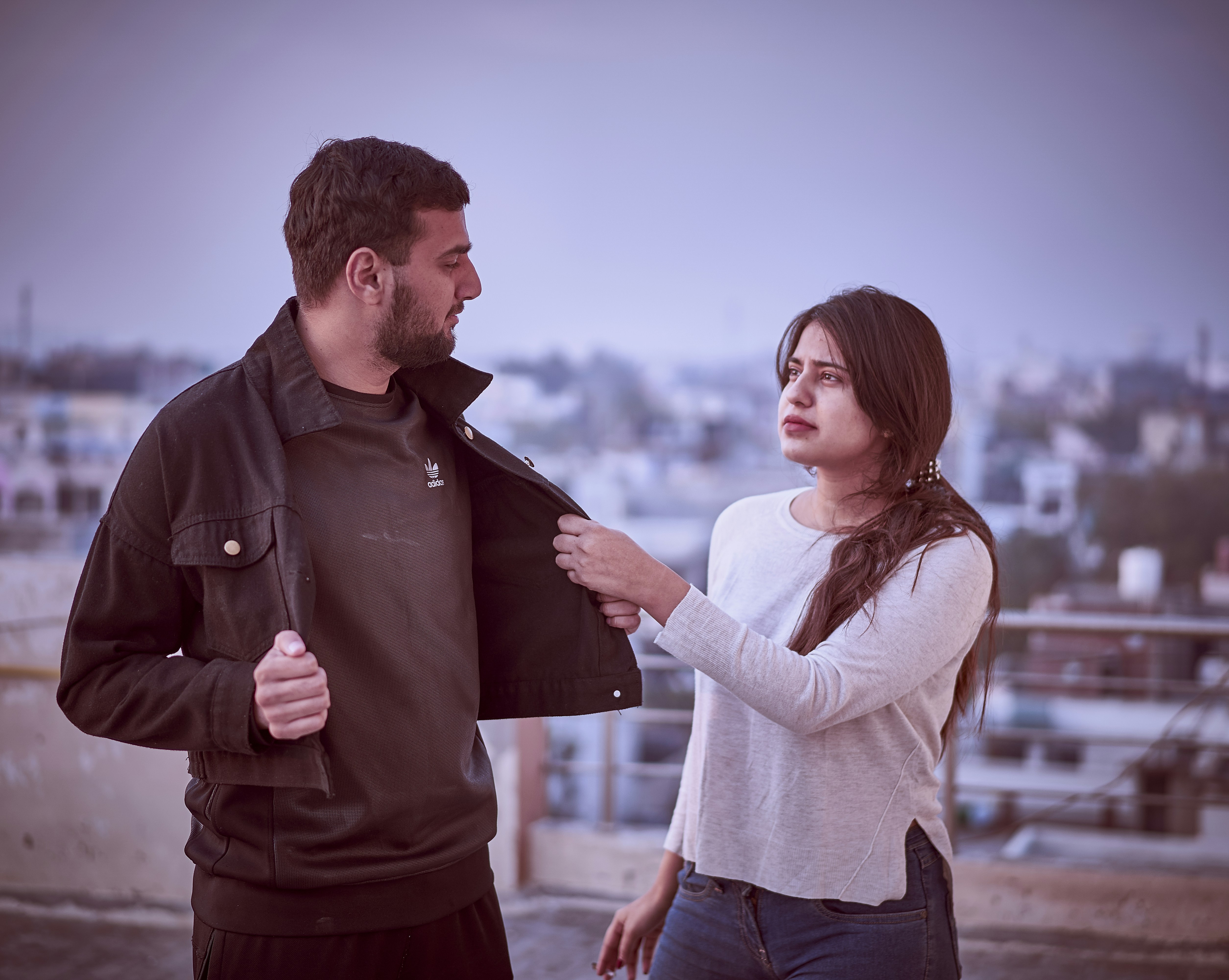 man in brown jacket and woman in white sweater standing on brown wooden dock during daytime