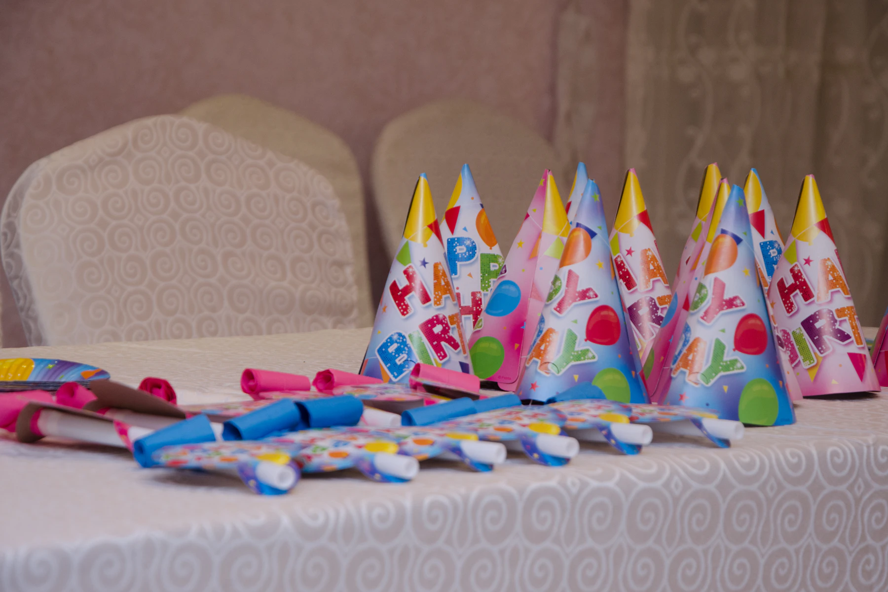 Birthday party hats and colorful party accessories arranged on a table