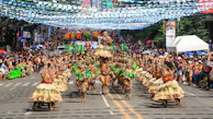 people in green and brown traditional dress walking on street during daytime