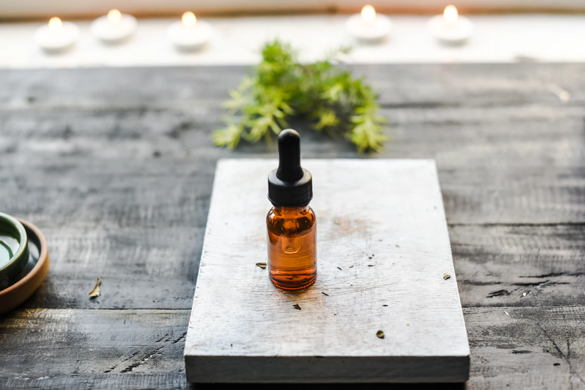 Aromatherapy essential oil bottles and candles on a wooden table, spa setting