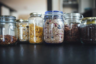 brown and white beans in clear glass jar