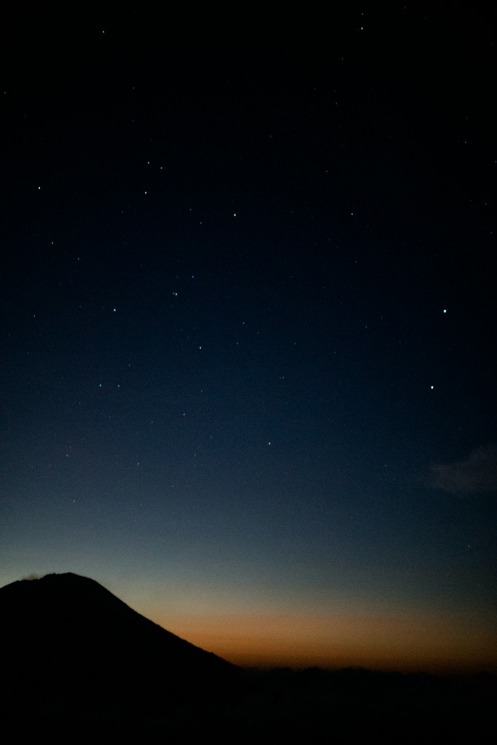 silhouette of mountain under blue sky during night time