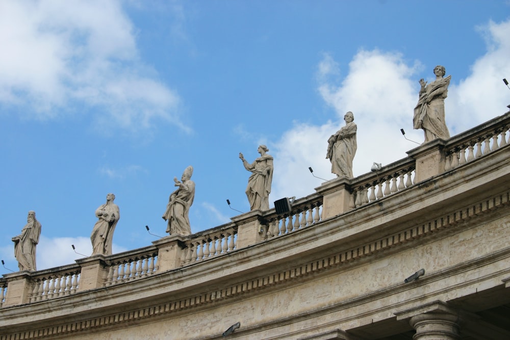 low angle photography of statue of men on top of building