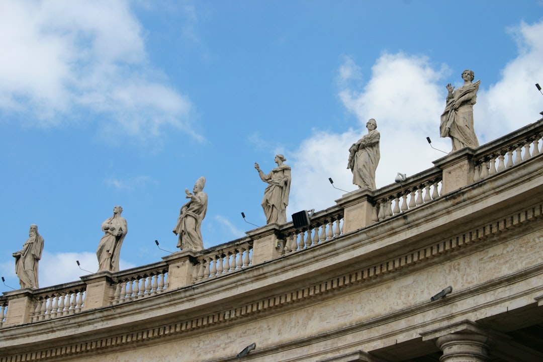 low angle photography of statue of men on top of building