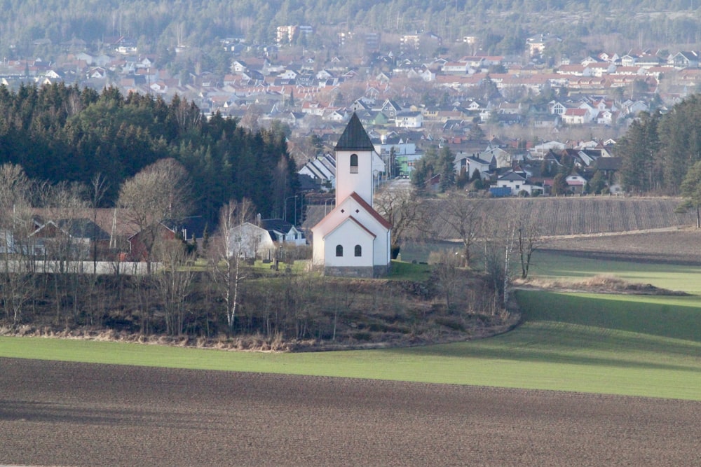 white and black house near green trees and green grass field during daytime