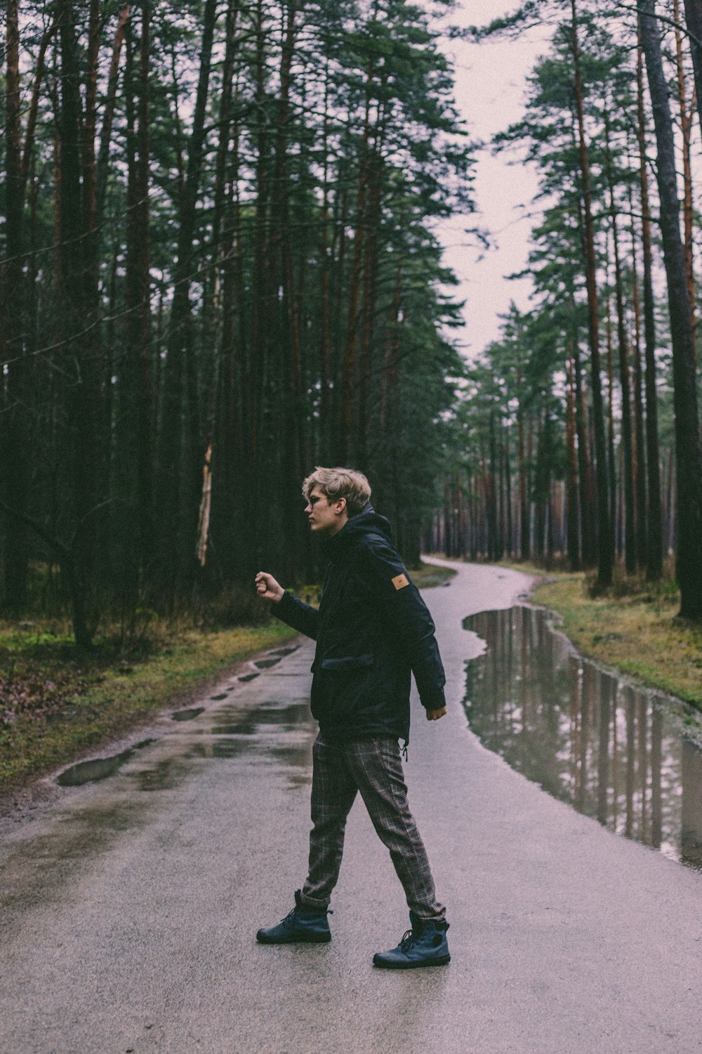 woman in black jacket walking on gray road during daytime