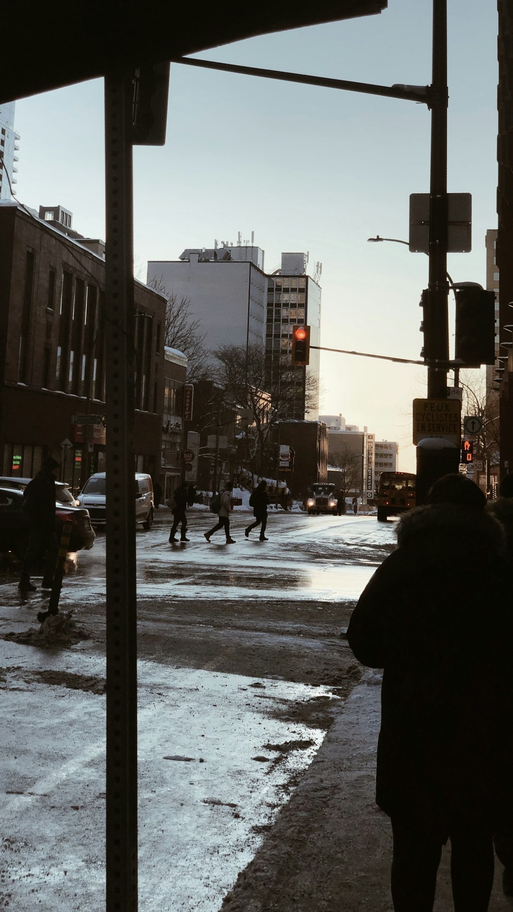 personne en manteau noir marchant dans la rue pendant la journée