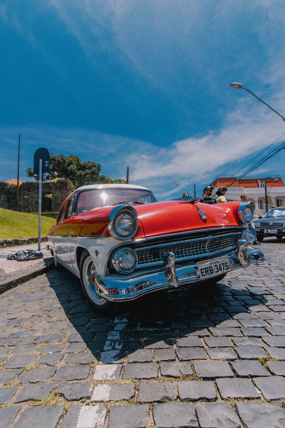red and white vintage car on gray concrete pavement