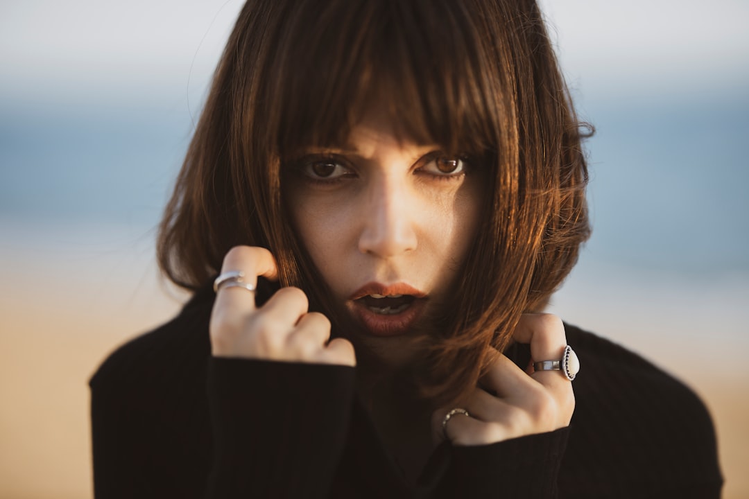 woman in black long sleeve shirt holding her chin