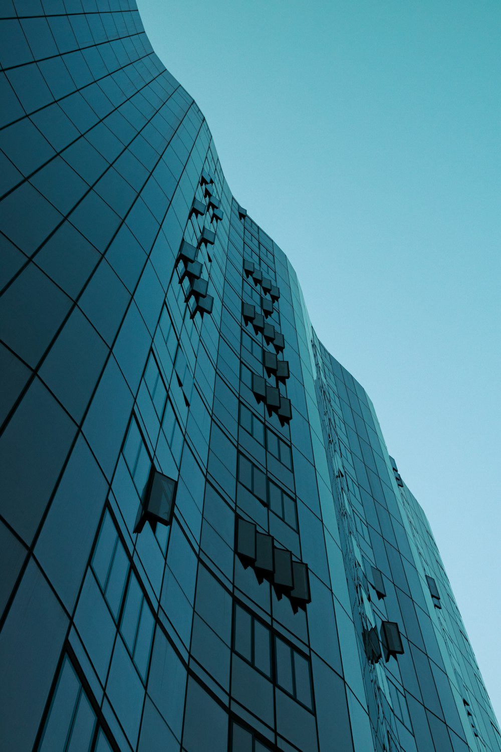 blue and white glass walled high rise building