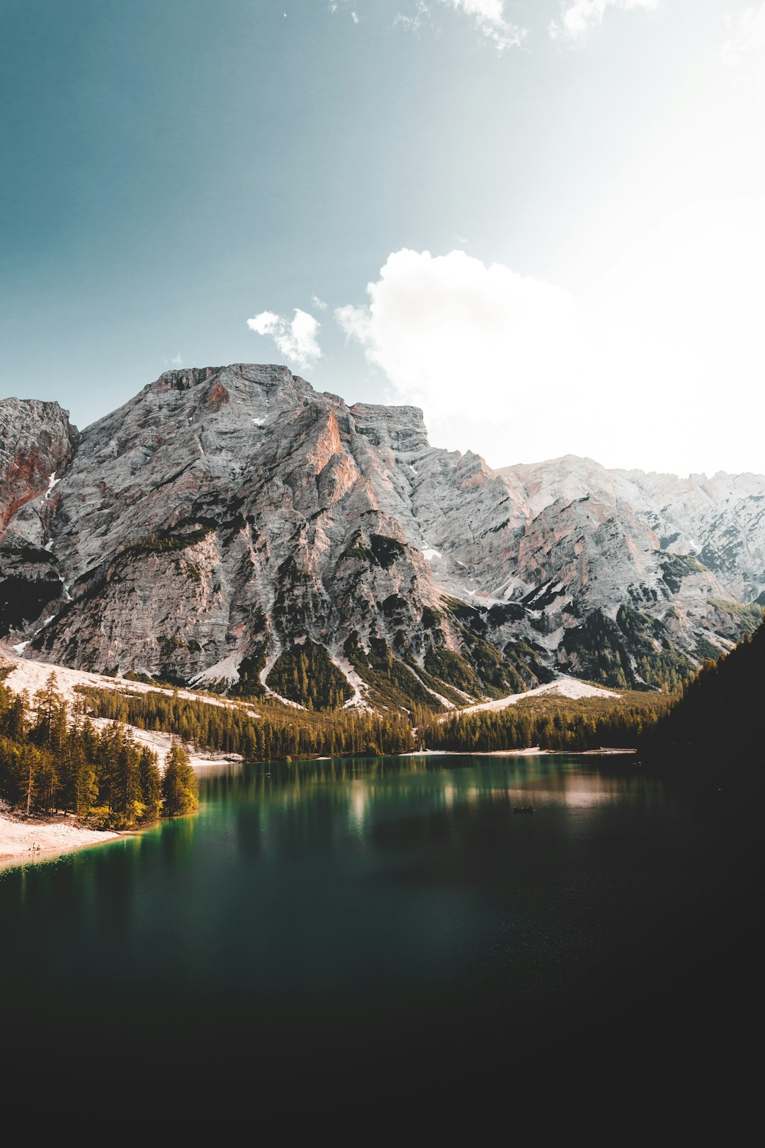 lake near mountain under blue sky during daytime