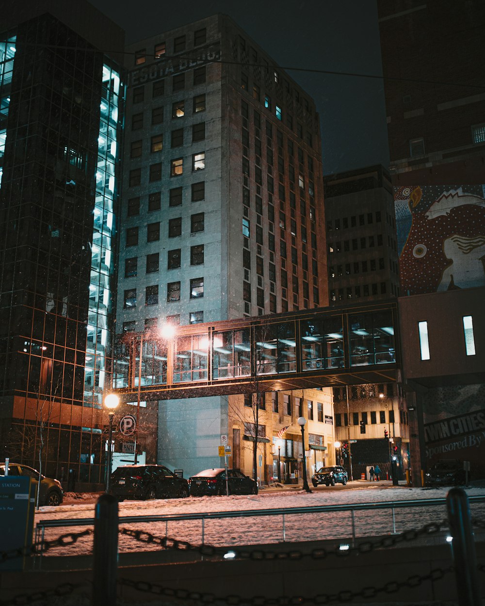 people walking on sidewalk near high rise buildings during night time