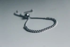 silver bracelet on white surface