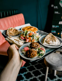person holding white ceramic plate with food