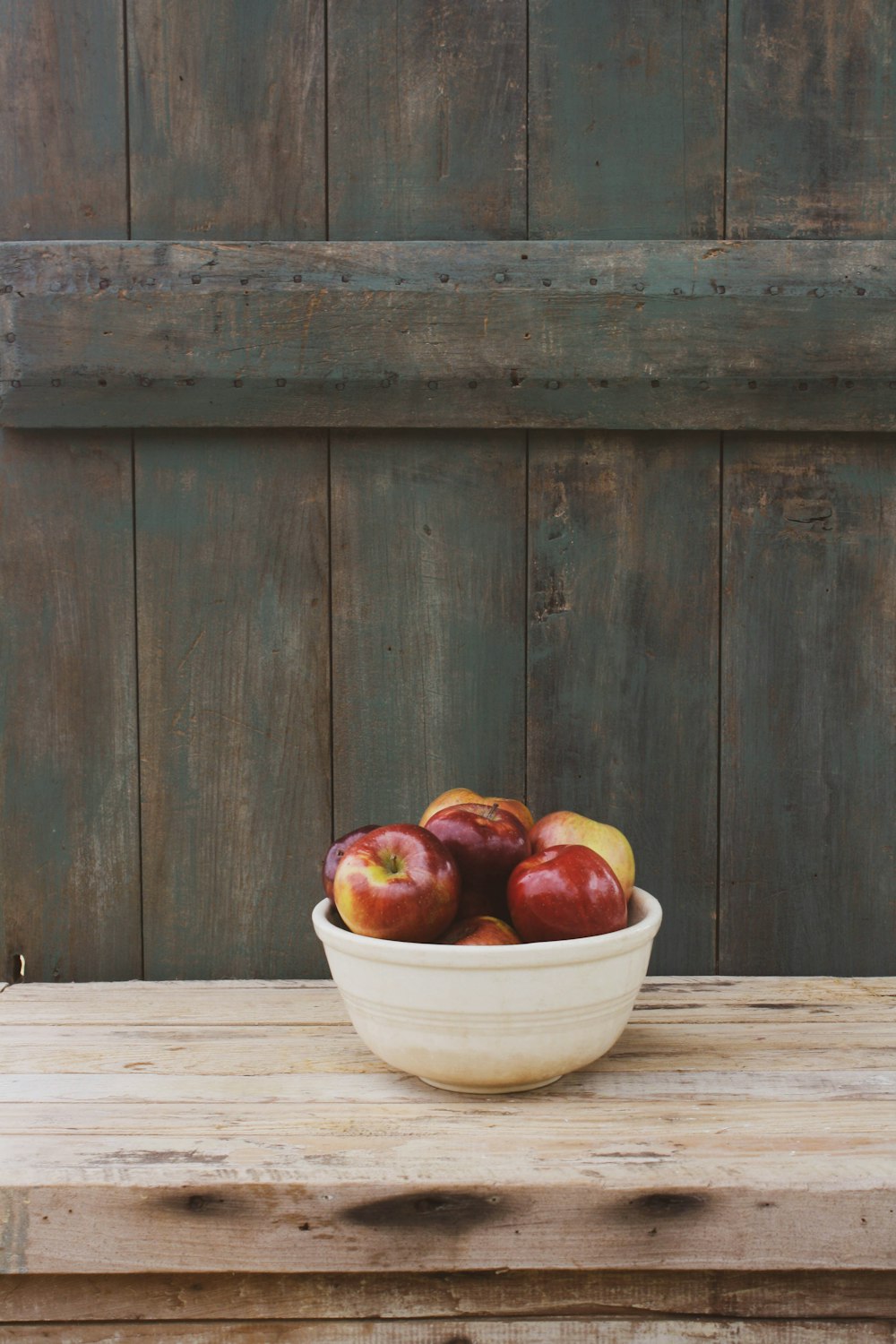 red apples in white ceramic bowl