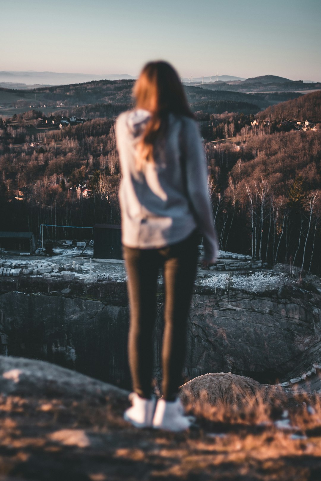 woman in white long sleeve shirt standing on rock