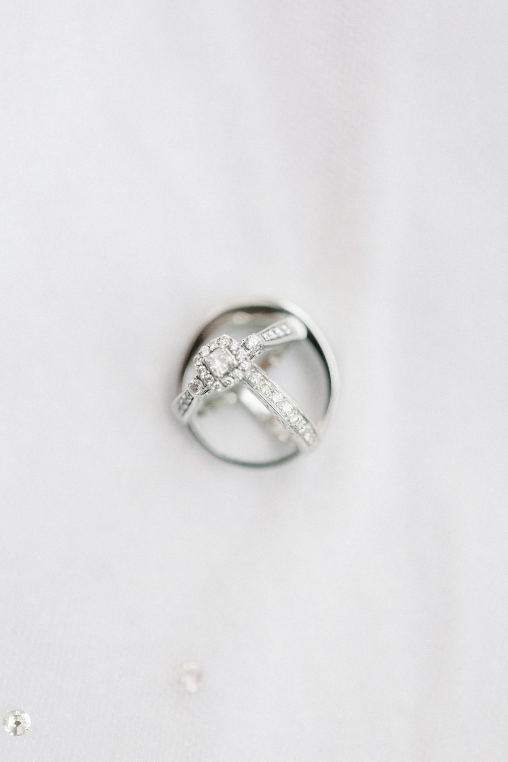 anel de diamante de prata no têxtil branco