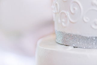 A close-up of a cake designed like a luxury watch face, surrounded by elegant baking tools.