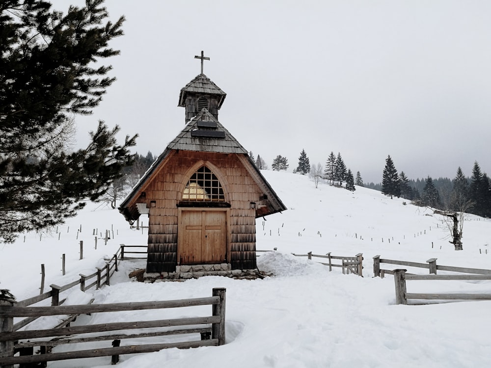 brown wooden house on snow covered ground during daytime