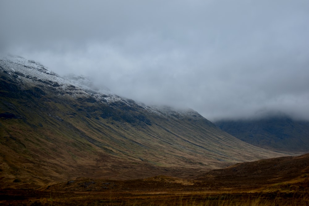 brown and gray mountain under white clouds