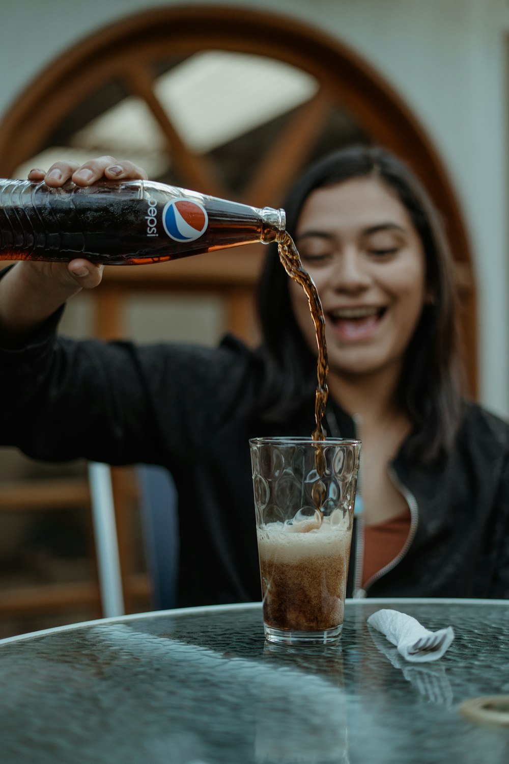 smiling woman holding clear drinking glass