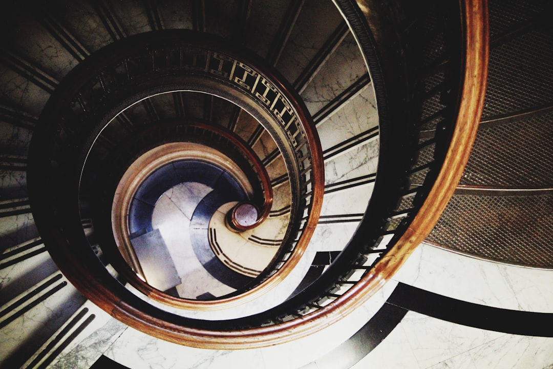 brown spiral staircase with brown wooden railings