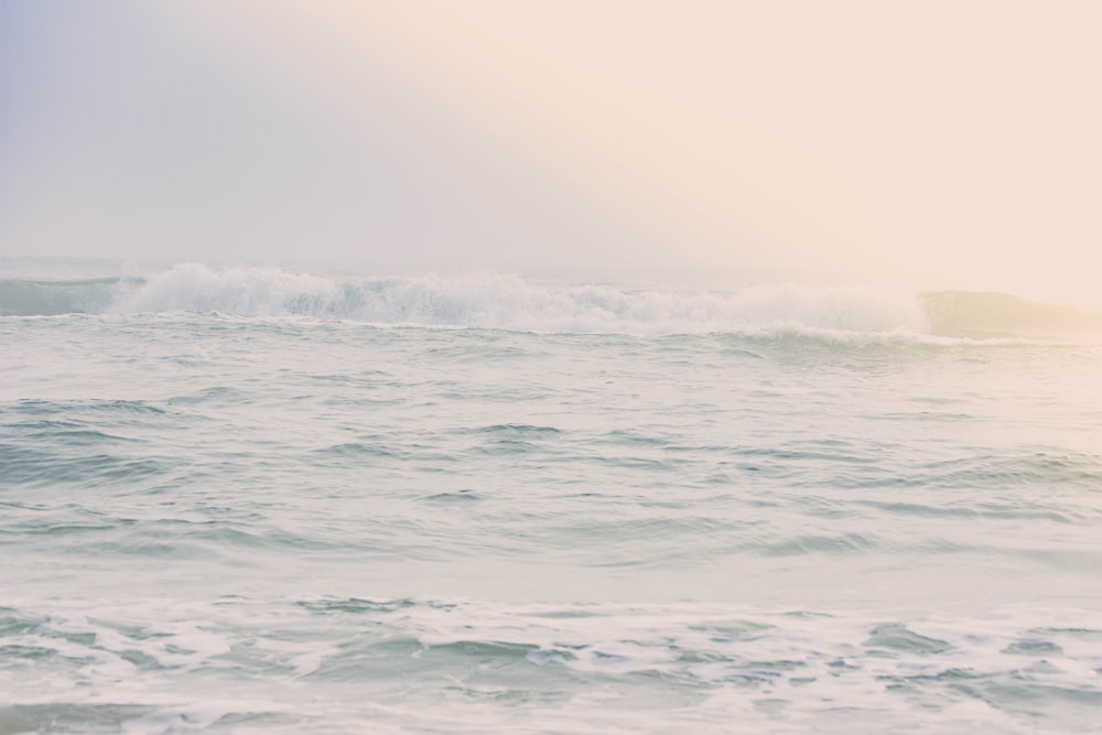 ocean waves under white sky during daytime