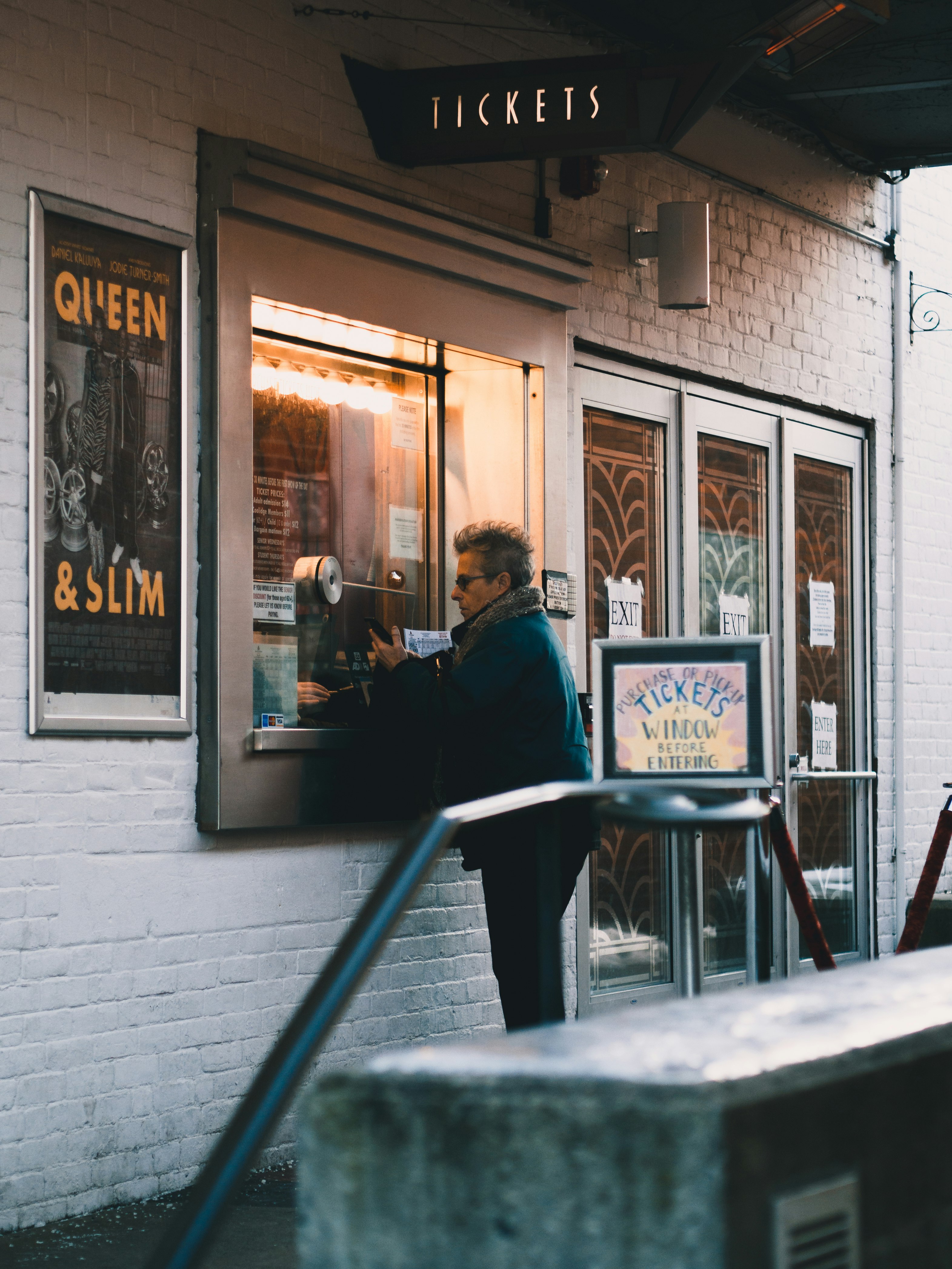 man in black jacket sitting on chair in front of store