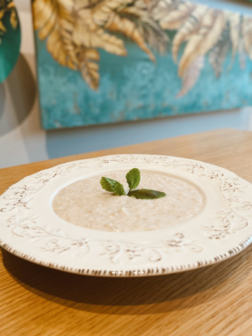 green leaf on white and blue ceramic round plate