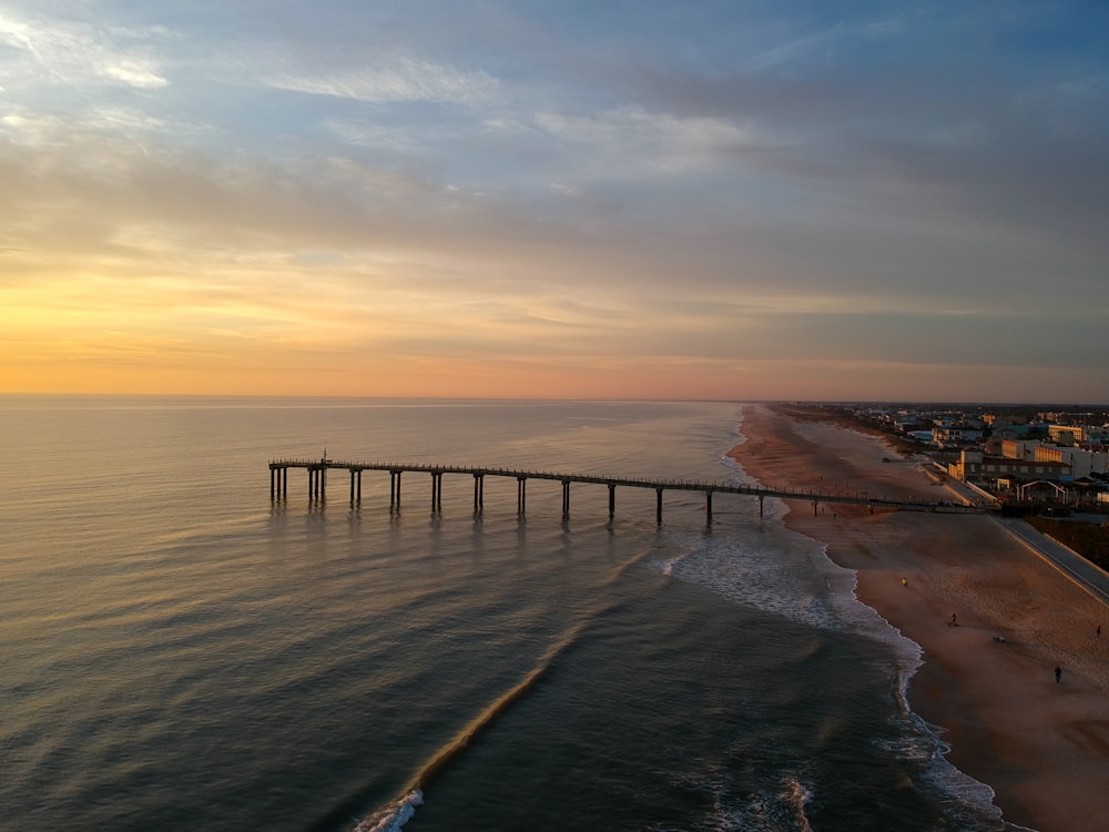 brown wooden dock on sea during sunset