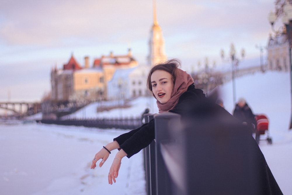 woman in black hoodie standing near building during daytime