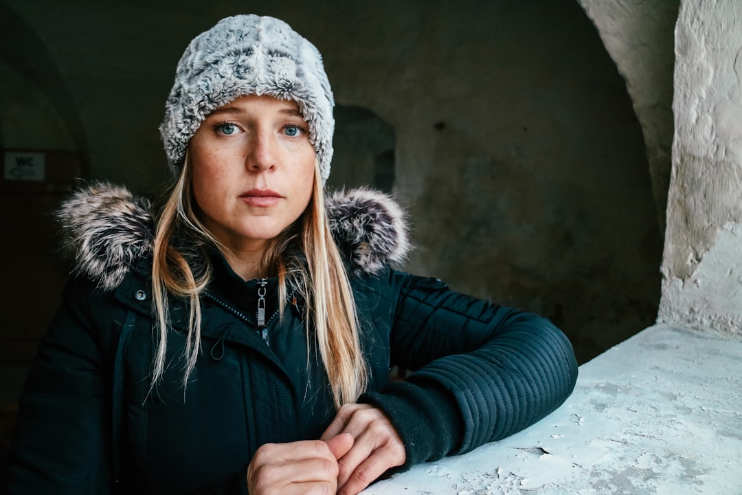 woman in black jacket wearing white knit cap