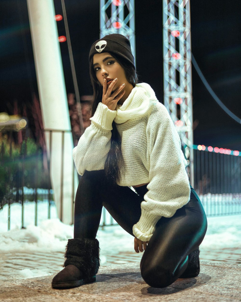 woman in white knit sweater and black pants sitting on brown wooden bench during daytime