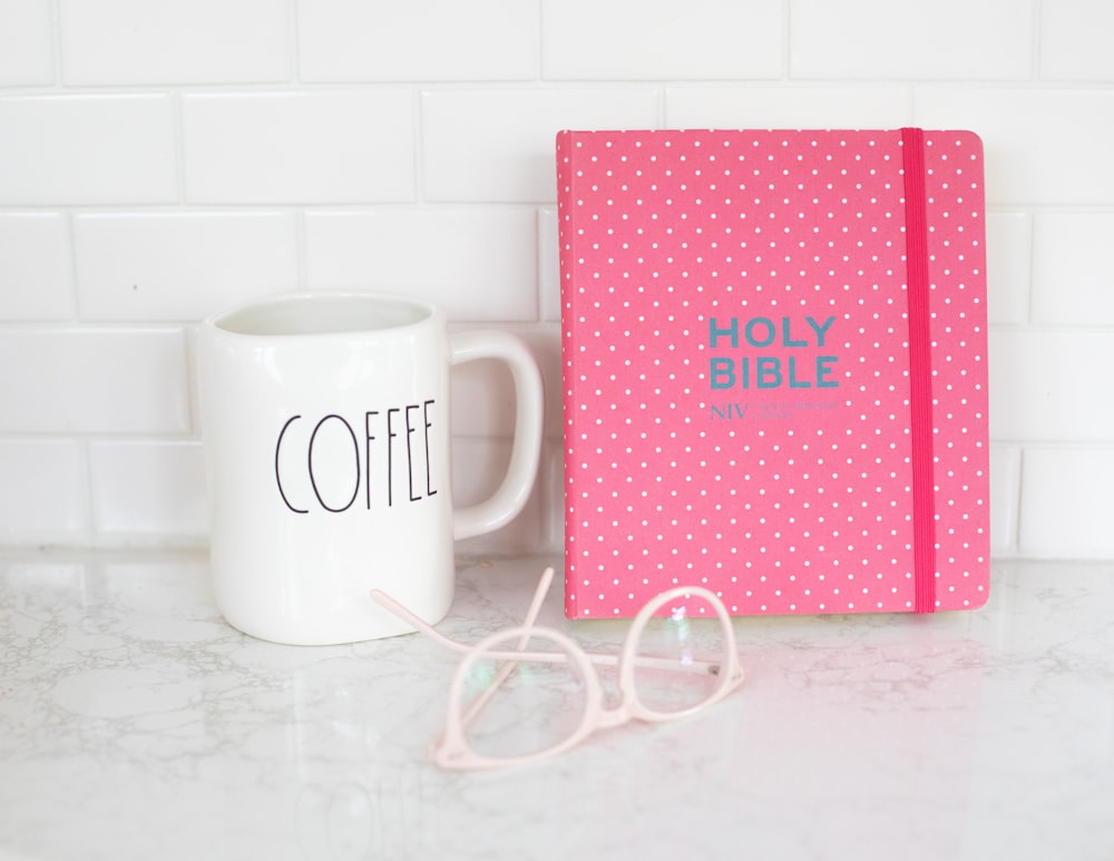 white ceramic mug beside pink and white heart print box