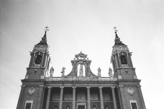 grayscale photo of concrete building in Almudena Cathedral Spain