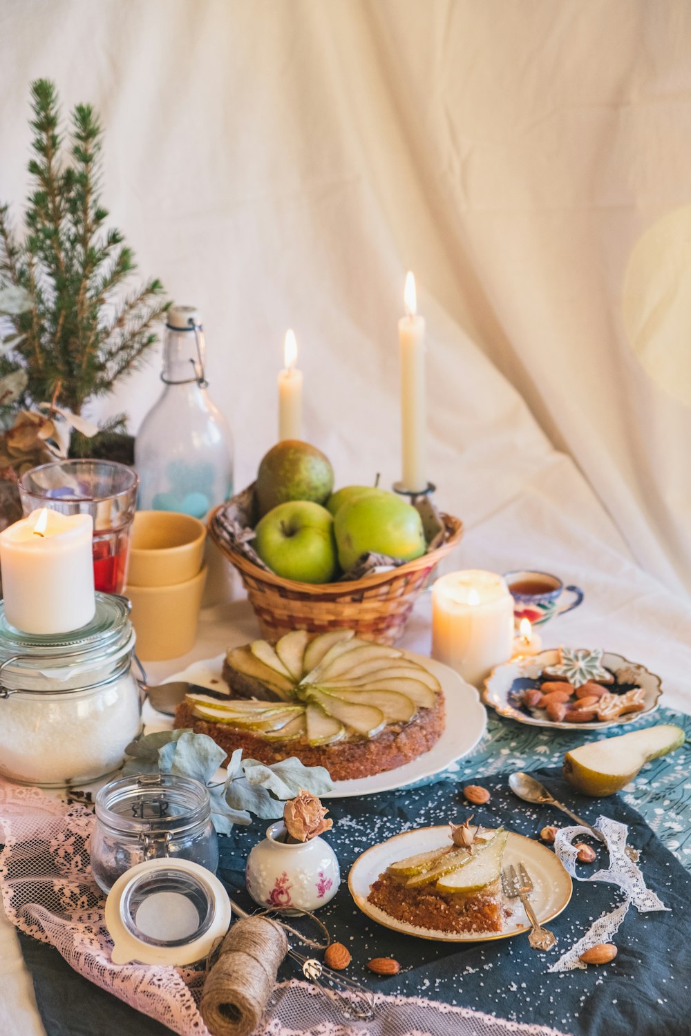 green apple fruit beside white pillar candles on brown wooden tray