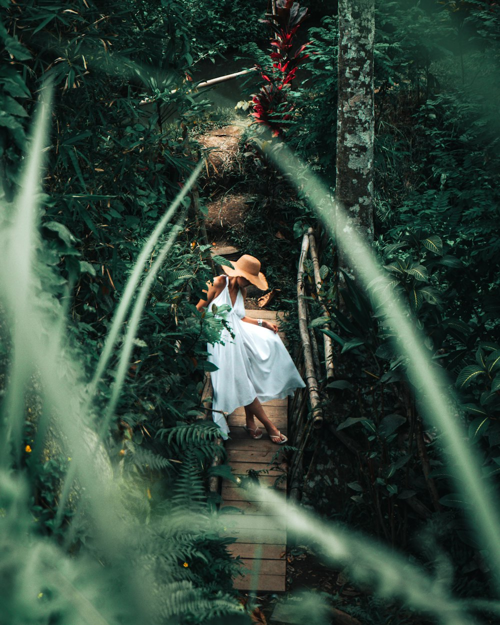 woman in white dress shirt and brown skirt standing on green plants during daytime