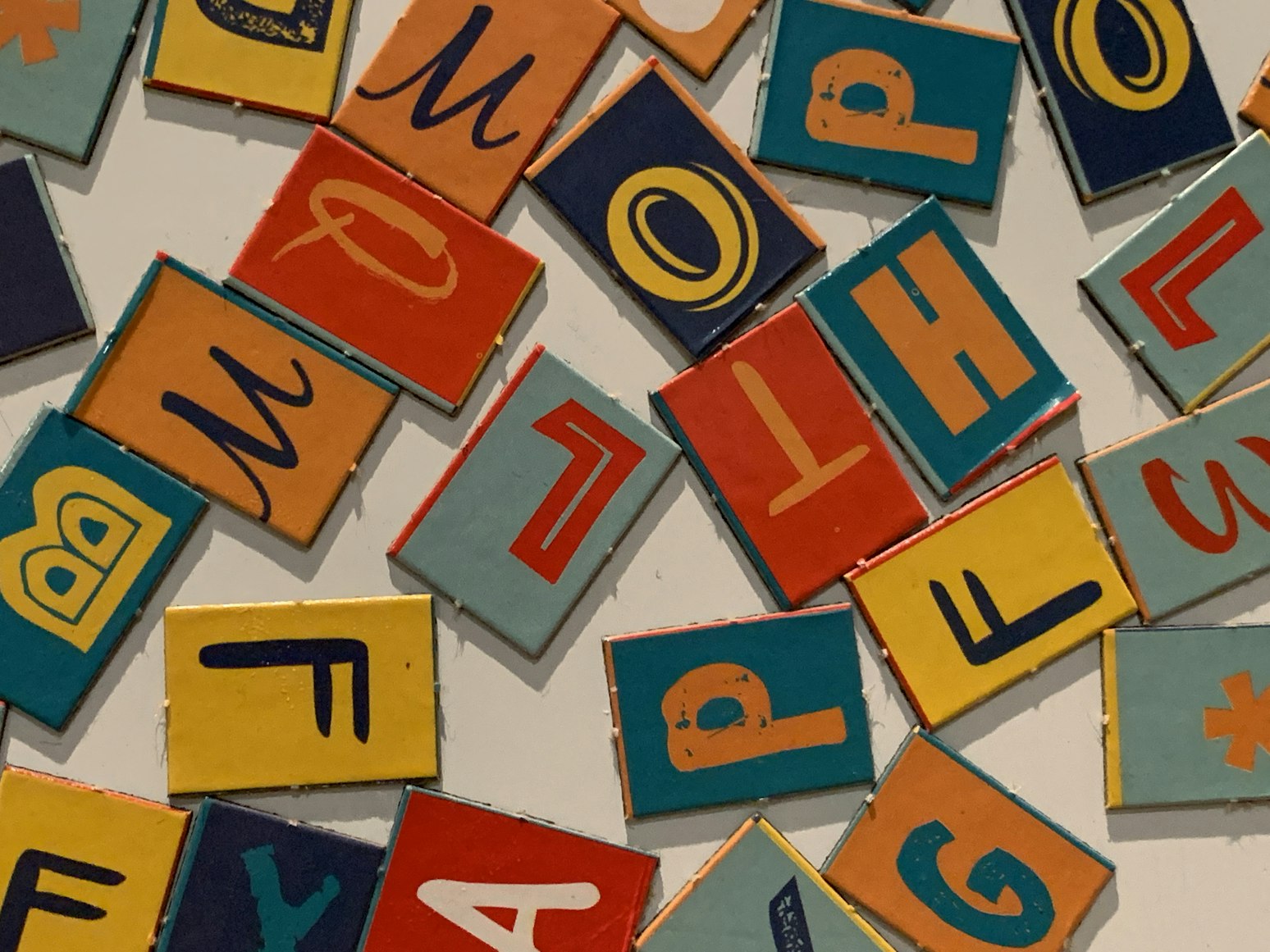 a close up of a pile of colorful wooden blocks with letters on them