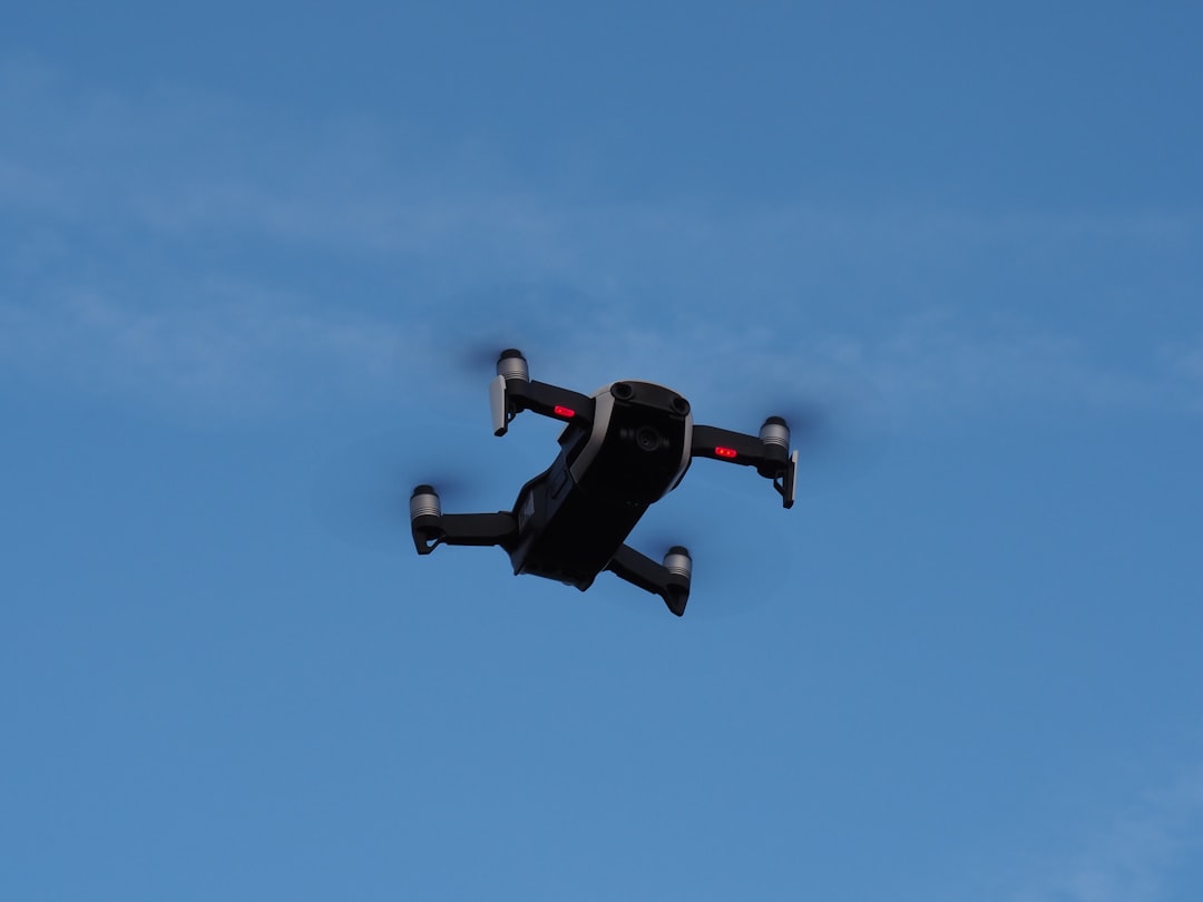 black and red drone flying under blue sky during daytime