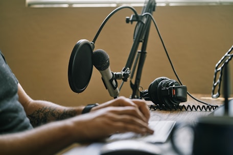 A close-up of a microphone set up for a podcast recording in a cozy studio environment.