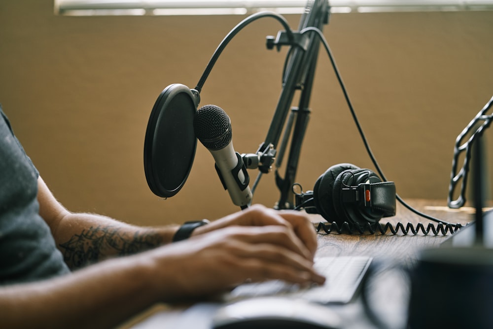 personne tenant le microphone sur le pied du microphone