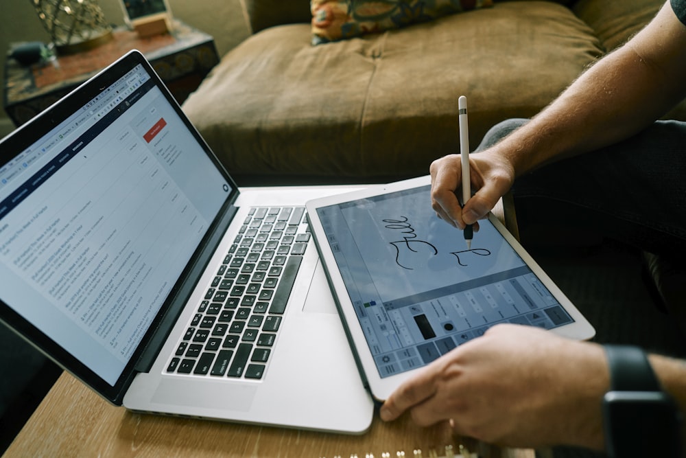 person using macbook pro on brown couch