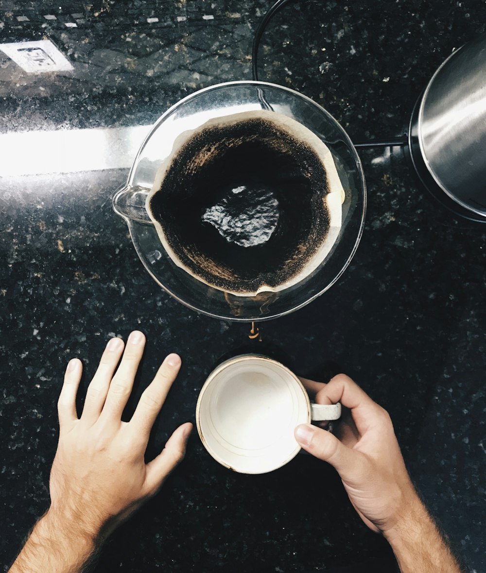 person holding white ceramic mug