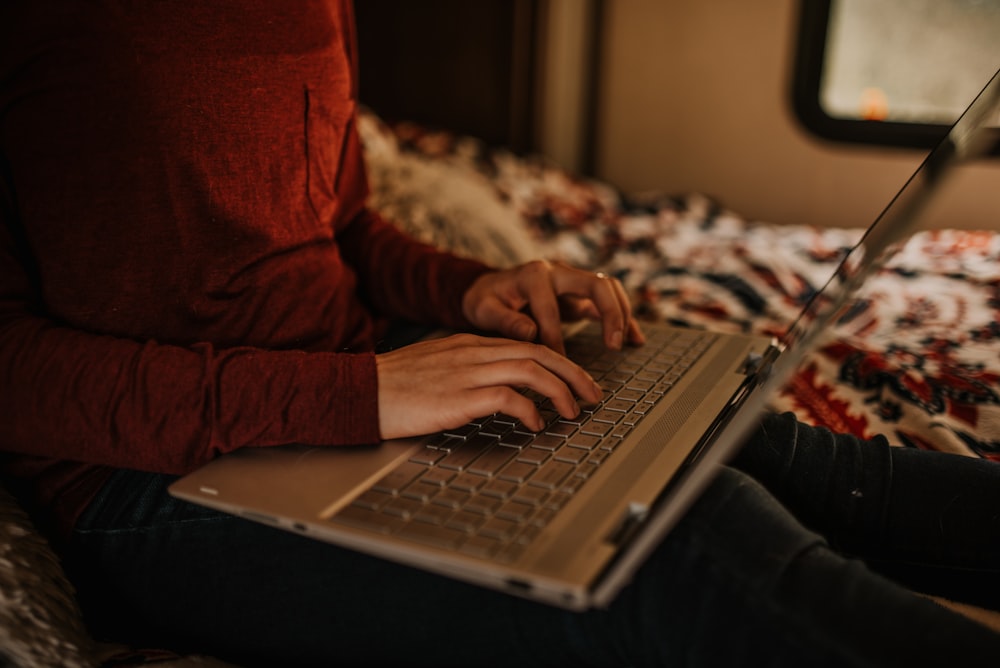 person in red sweater using macbook pro