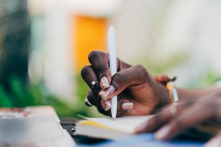 Close-up of writing notes for a long-form YouTube pilot strategy