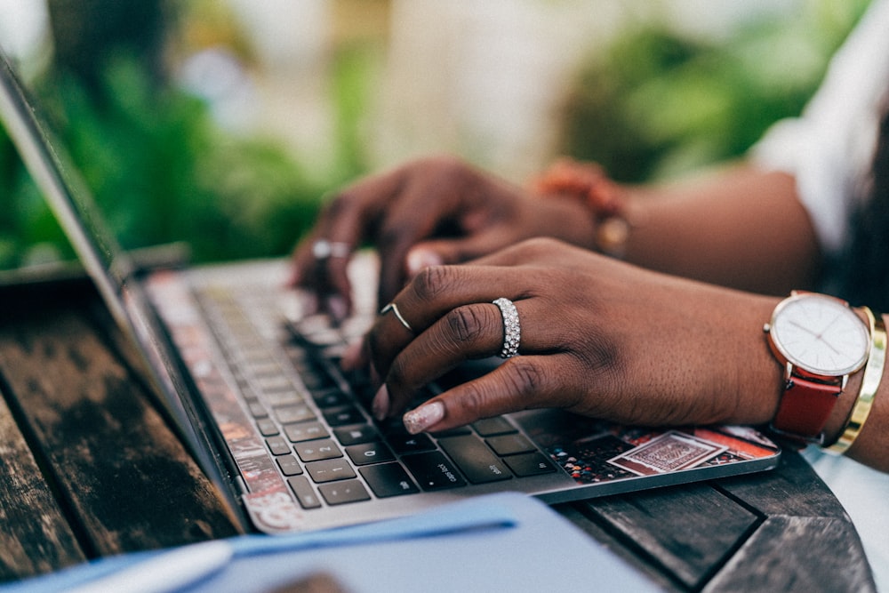 person wearing silver ring using macbook pro