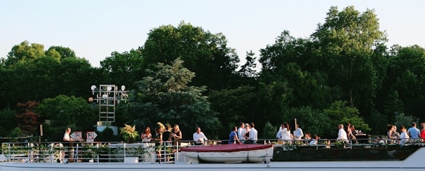 An elegant yacht deck set up for a sunset party with guests enjoying the sea breeze.