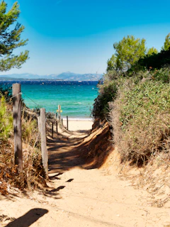 A serene sandy pathway leading from the resort to the turquoise waters of Bang Tao Beach