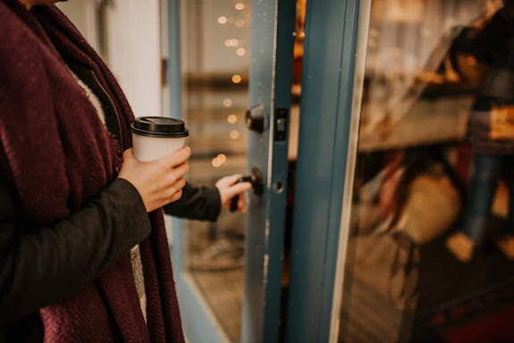 person holding black and white coffee cup