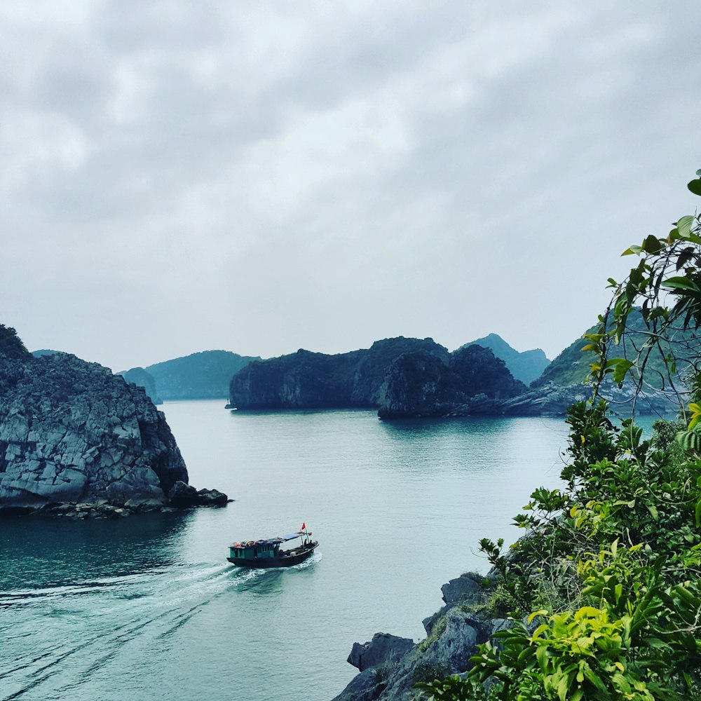 boat on water near mountain during daytime